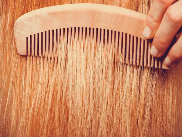 Mulher loira escovando o cabelo com pente — Fotografia de Stock