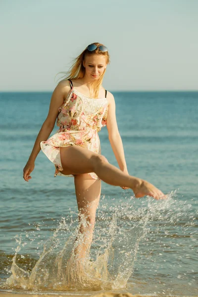 Kvinnan bär klänning leker med vatten i havet — Stockfoto