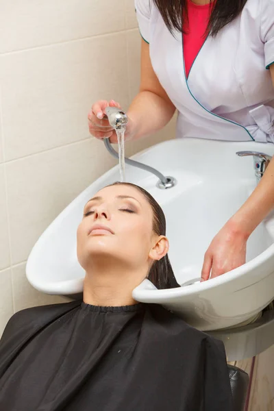 Hairdresser washing her woman customer hair — Stock Photo, Image