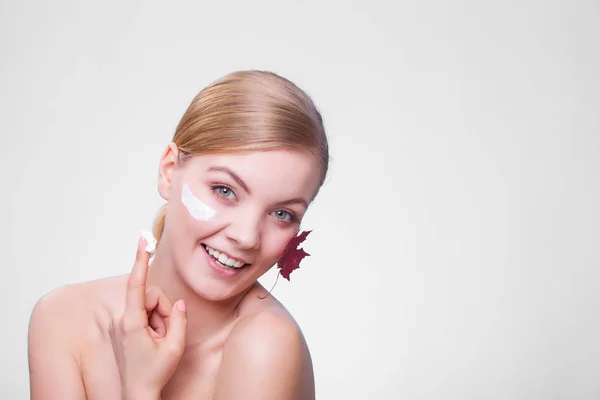 Soins de la peau. Visage de jeune femme fille avec feuille d'érable rouge. — Photo