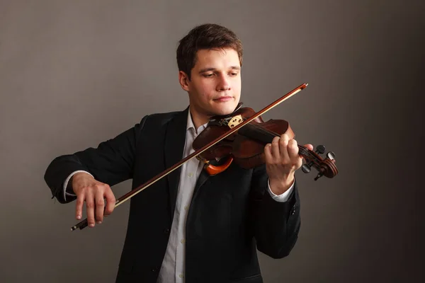 Mies pukeutunut tyylikkäästi soittaa viulua — kuvapankkivalokuva
