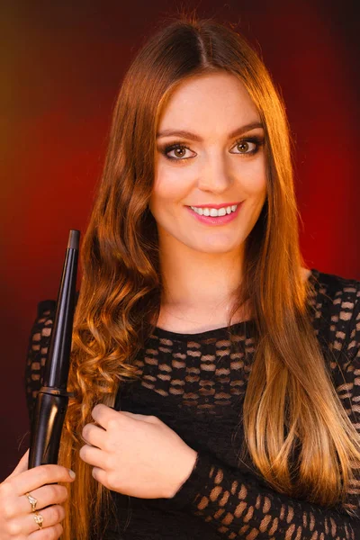 Happy woman curling her long brown hair — Stock Photo, Image