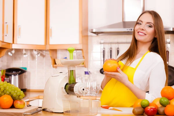 Женщина на кухне готовит фрукты для сока — стоковое фото