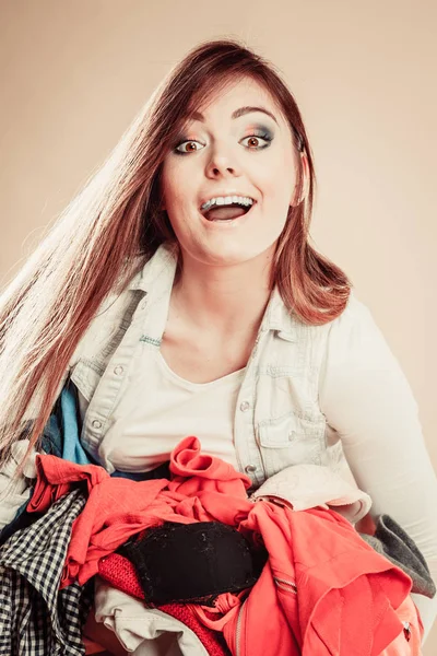 Усміхнена дівчина тримає купу одягу . — стокове фото