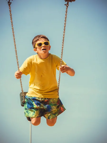 Junge spielt schaukelnd an Schaukel-Set. — Stockfoto