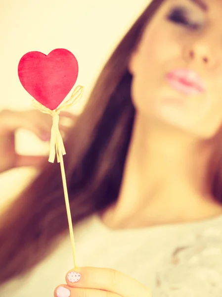 Hermosa mujer sosteniendo corazón en forma de palillo — Foto de Stock