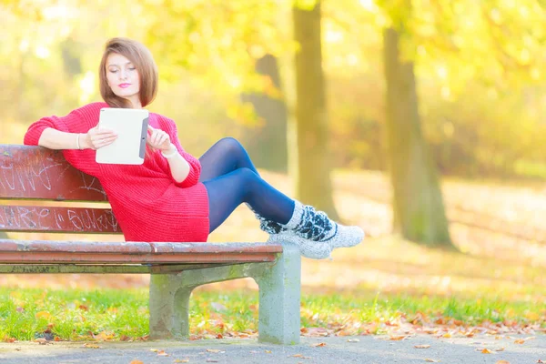 Donna su panca in parco con tablet . — Foto Stock