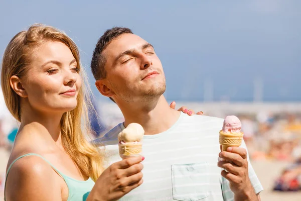 Mężczyzna i kobieta jedzący lody na plaży — Zdjęcie stockowe