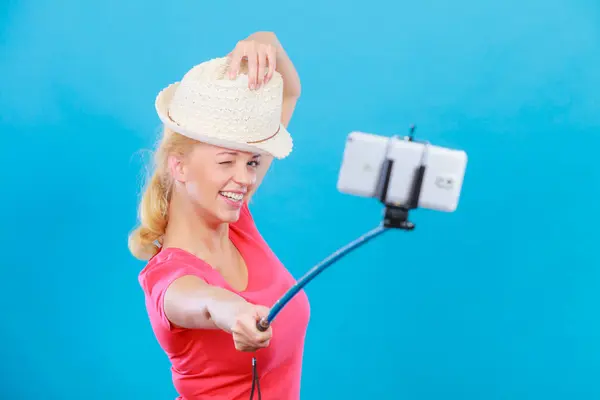 Mujer tomando fotos de sí misma con el teléfono en el palo — Foto de Stock