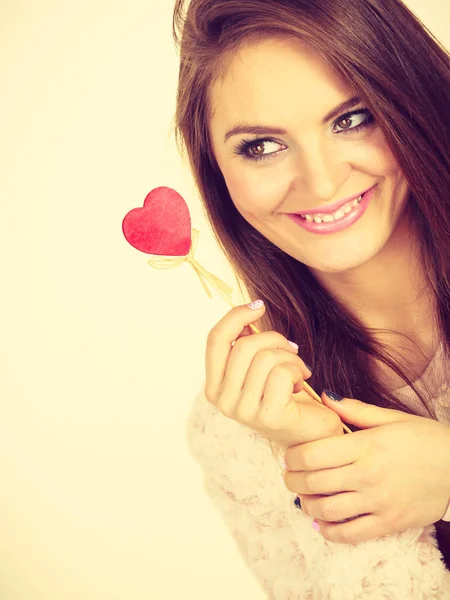 Mujer coqueta sosteniendo el corazón de madera roja en palo — Foto de Stock