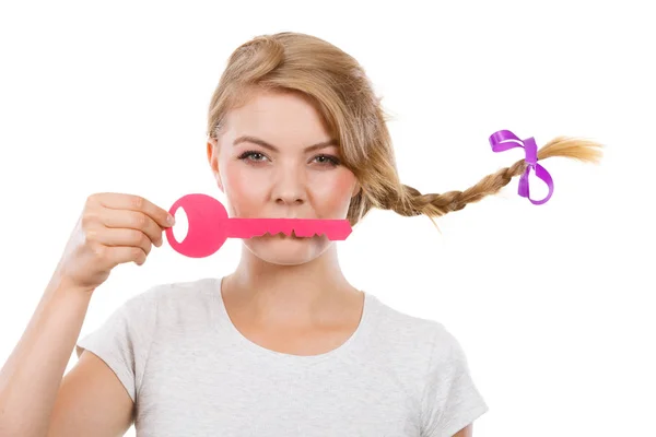 Teenager-Mädchen mit Zopf hält Schlüssel auf den Lippen — Stockfoto
