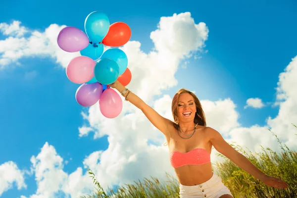 Girl holding balloons sky background — Stock Photo, Image