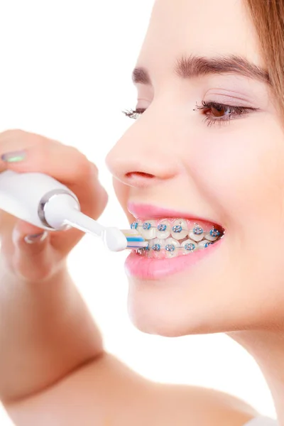 Женщина улыбается чистка зубов с брекетами — стоковое фото