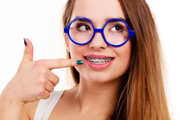 Nerd mujer mostrando sus dientes con aparatos ortopédicos — Foto de Stock