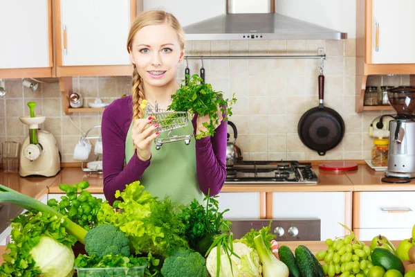 Žena v kuchyni zeleninu drží nákupní košík — Stock fotografie