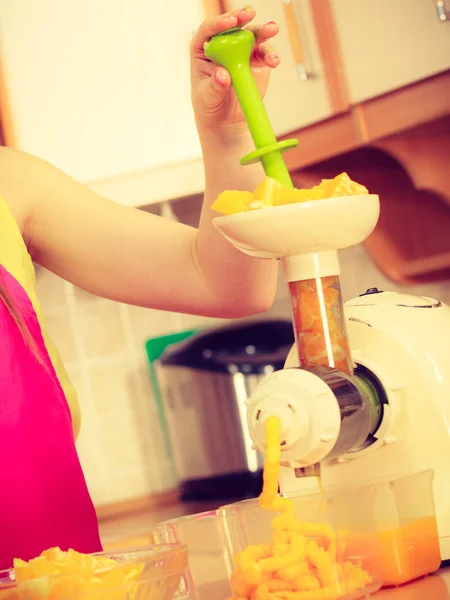 Vrouw maken van sinaasappelsap in juicer machine — Stockfoto