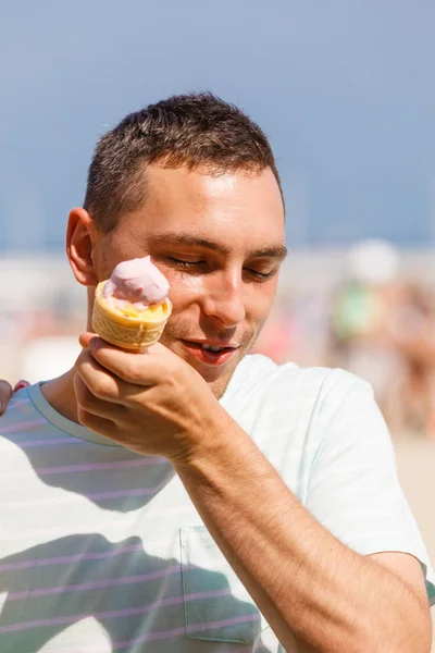 Szczęśliwy człowiek jedzenie lody na plaży — Zdjęcie stockowe