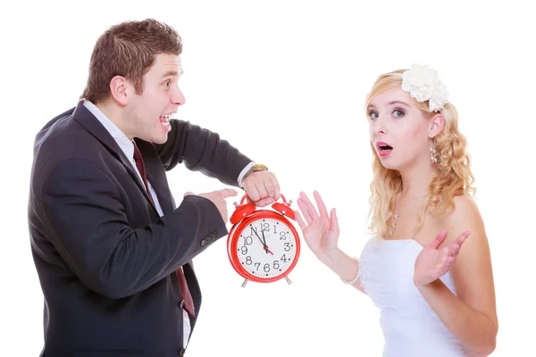 Groom holding big red clock yelling and bride Stock Image