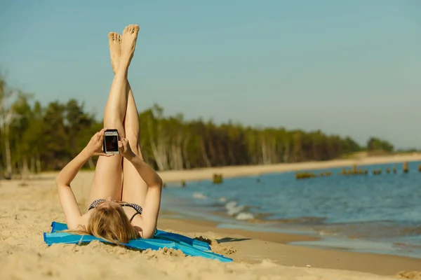 Güneşlenme ve dinlenme Sahilde bikinili kadın — Stok fotoğraf