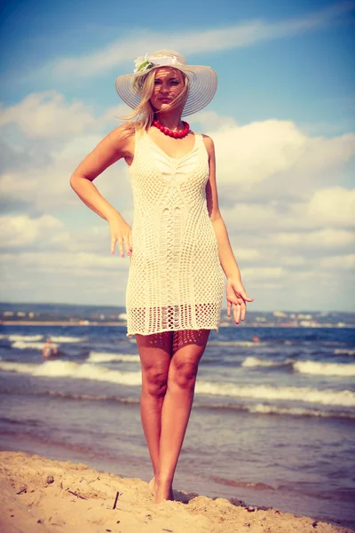Femme blonde portant une robe marchant sur la plage — Photo