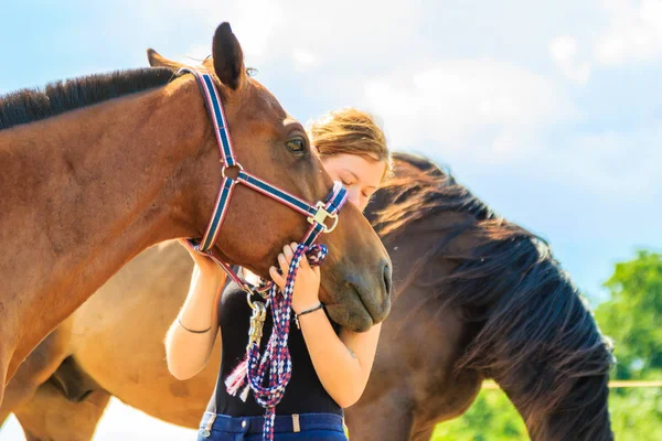 Jockey young girl petting and hugging brown horse — Stock Photo, Image