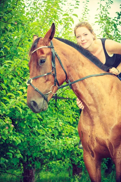 Jovem mulher abraçando e sentado no cavalo — Fotografia de Stock