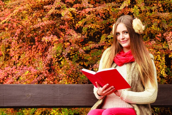 Woman relaxing in autumnal park reading book — Stock Photo, Image