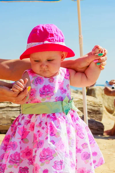 Criança segurando mãos adultas na praia — Fotografia de Stock