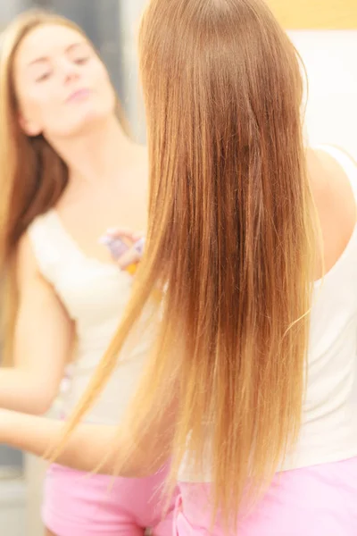 Mujer cuidando su cabello largo aplicando aceite cosmético — Foto de Stock