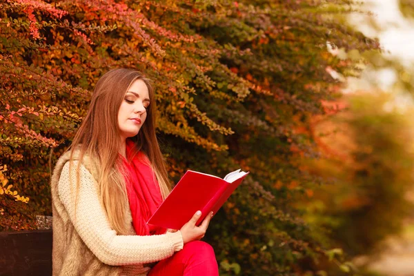 Woman relaxing in autumnal park reading book — Stock Photo, Image