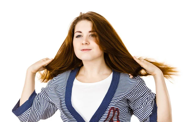 Giovane donna che tocca i suoi lunghi capelli castani — Foto Stock