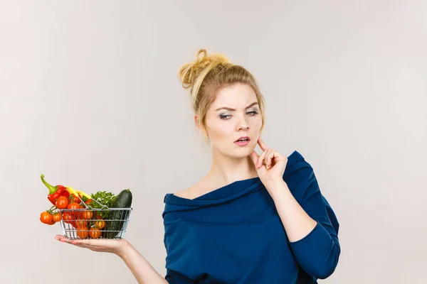 Woman with vegetables, thinking face expression