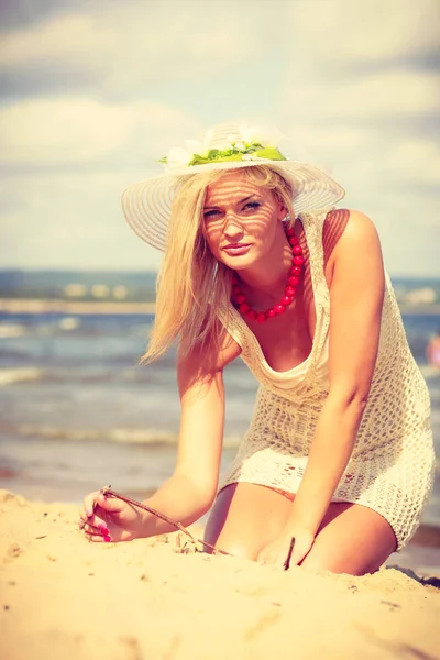Aantrekkelijke dame, zittend op het zand. — Stockfoto