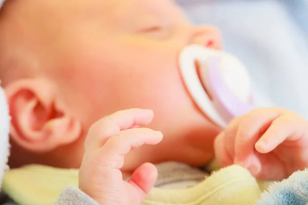 Closeup of little newborn sleeping with teat in mouth — Stock Photo, Image