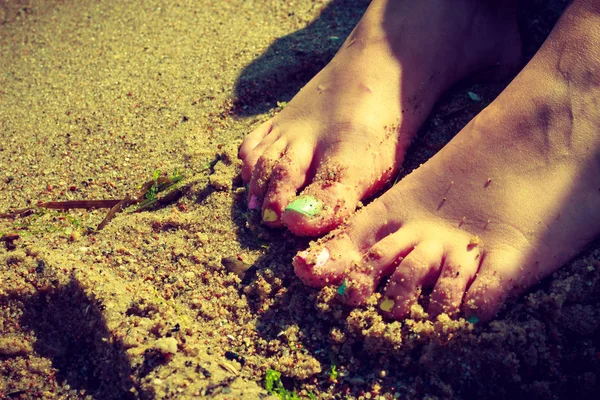 Woman feet with nail polish on sand — Stock Photo, Image