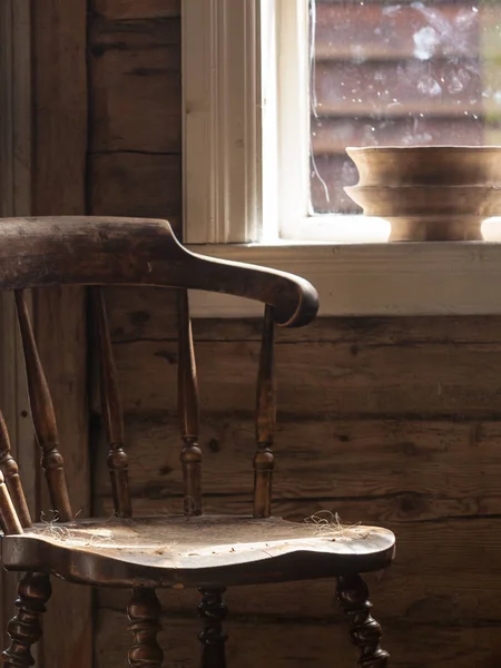 Retro dřevěná židle, staré chatě vedle okna — Stock fotografie