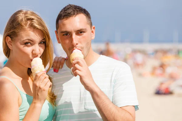 Mężczyzna i kobieta jedzący lody na plaży — Zdjęcie stockowe