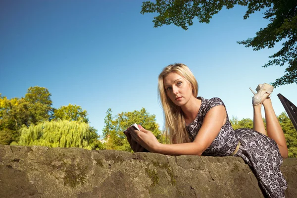 女人坐在公园里，放松和使用电话 — 图库照片