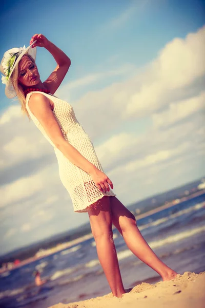 Blonde vrouw dragen jurk wandelen op strand — Stockfoto