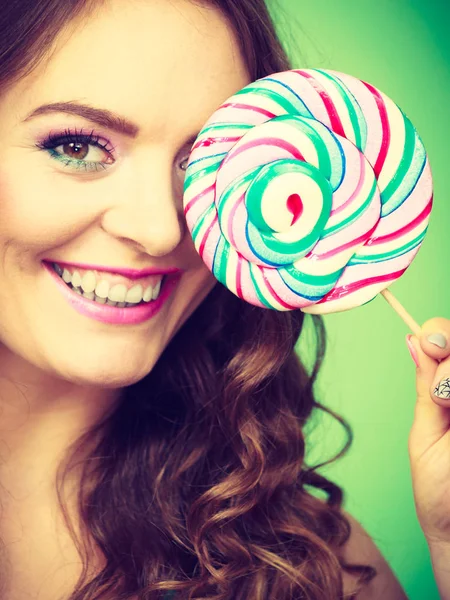 Usmívající se dívka s lízátkem cukroví na zelené — Stock fotografie