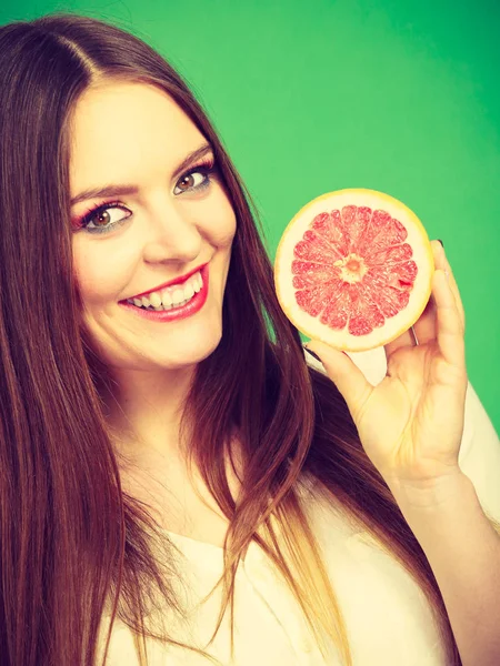 Kobieta trzyma pół grejpfruta owoców cytrusowych w ręku — Zdjęcie stockowe