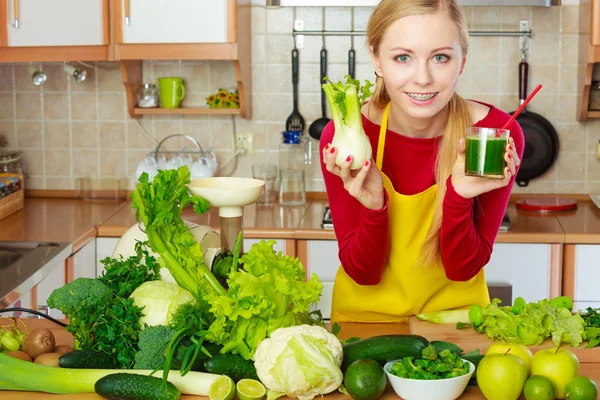 Donna in cucina con succo di frullato di finocchio vegetale Immagini Stock Royalty Free