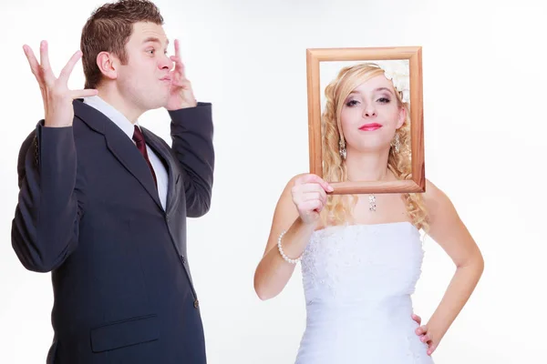Angry groom and bride holding empty frame Stock Picture