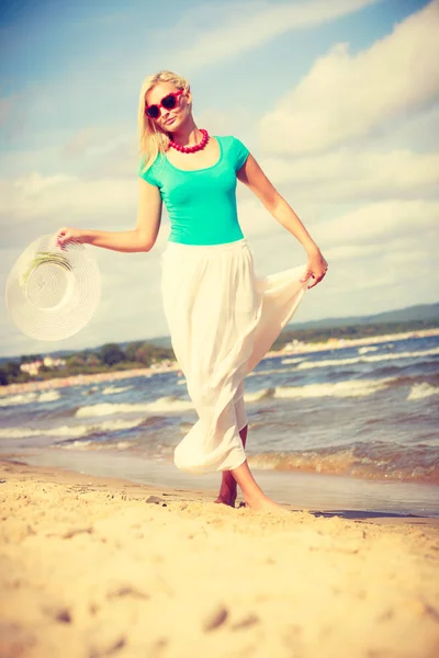 Donna bionda che indossa un vestito camminando sulla spiaggia — Foto Stock