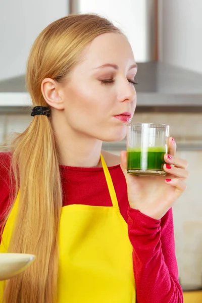 Woman in kitchen holding vegetable smoothie juice — Stock Photo, Image