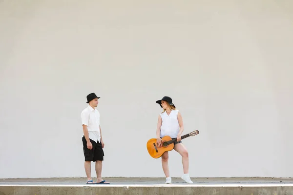 Женщина играет на гитаре, мужчина стоит рядом с ней — стоковое фото