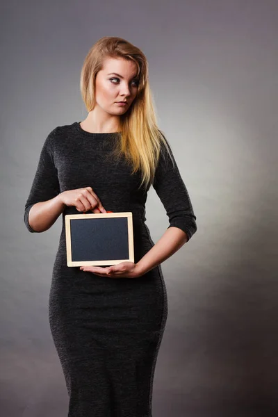 Woman holding blank black board on stomach — Stock Photo, Image