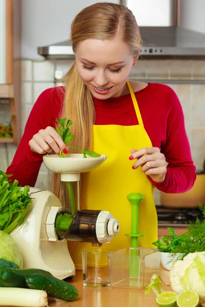 Mulher na cozinha fazendo suco de smoothie vegetal — Fotografia de Stock