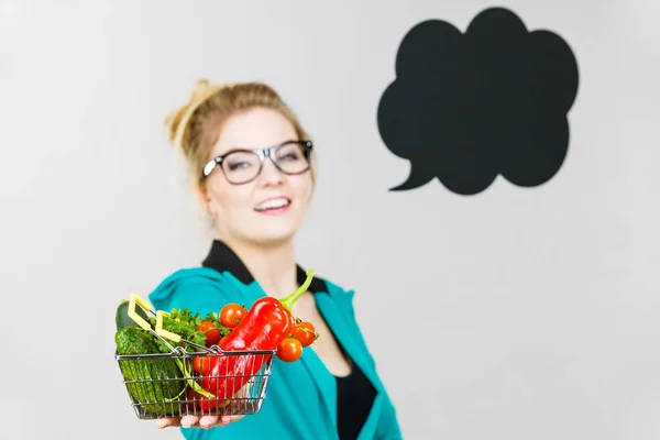Mulher segura carrinho de compras com legumes, espaço de cópia — Fotografia de Stock