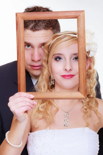 Brudgummen och bruden håller tom ram — Stockfoto